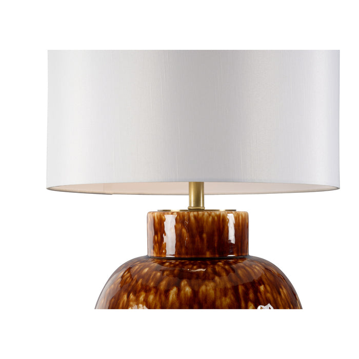 Table lamp with a tortoiseshell base and white shade on a white background