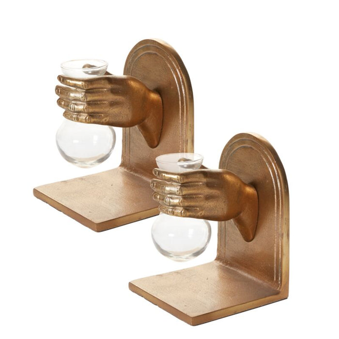 Bronze wall sconce with two hands holding glass bulbs on a white background