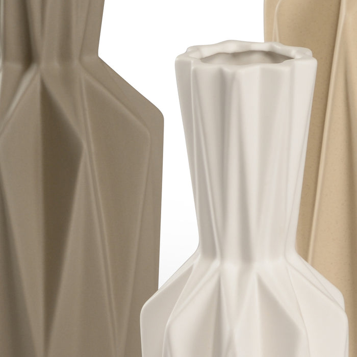 White vase with geometric design against a beige curtain background
