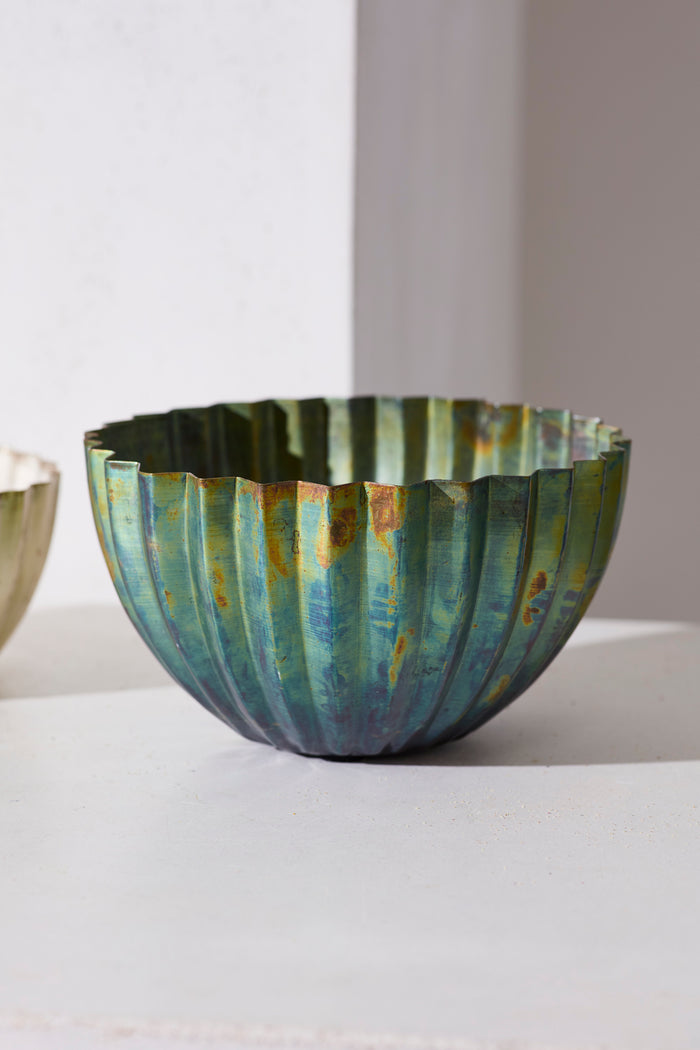 Decorative glass bowl with ribbed texture on a white surface