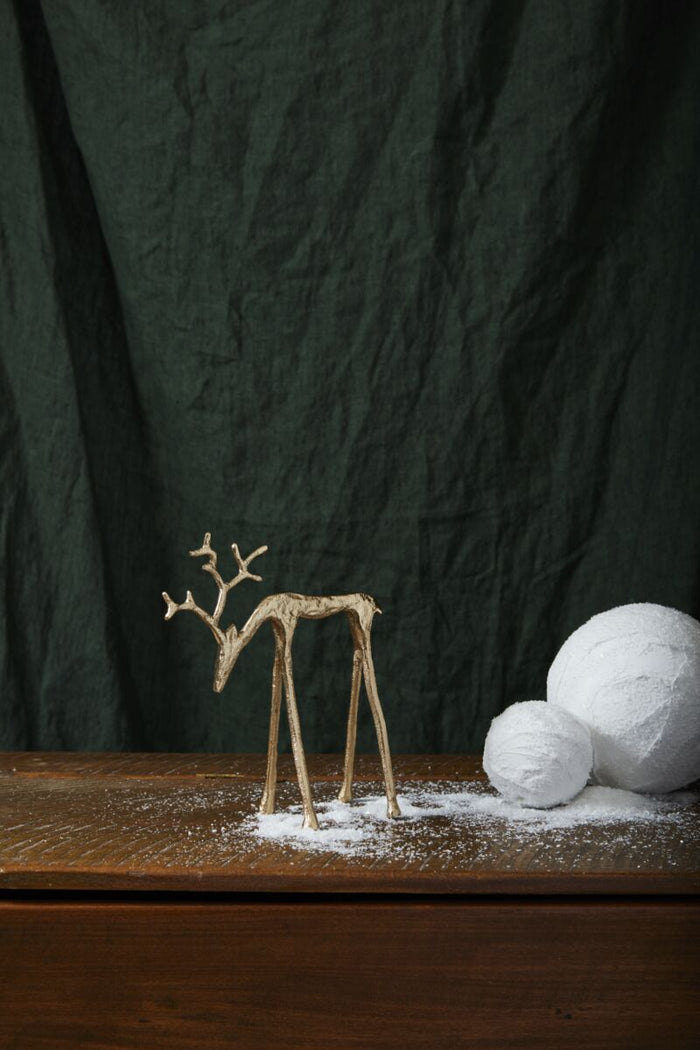 Decorative reindeer figure and white spherical objects on a dark background
