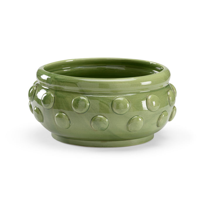 Green ceramic bowl with raised circular patterns on a white background