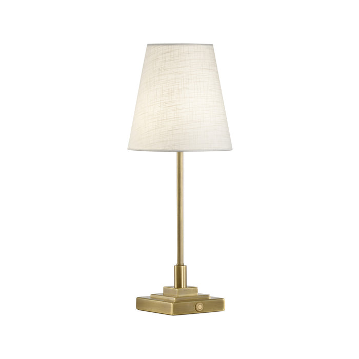 Table lamp with a white shade and gold base on a white background