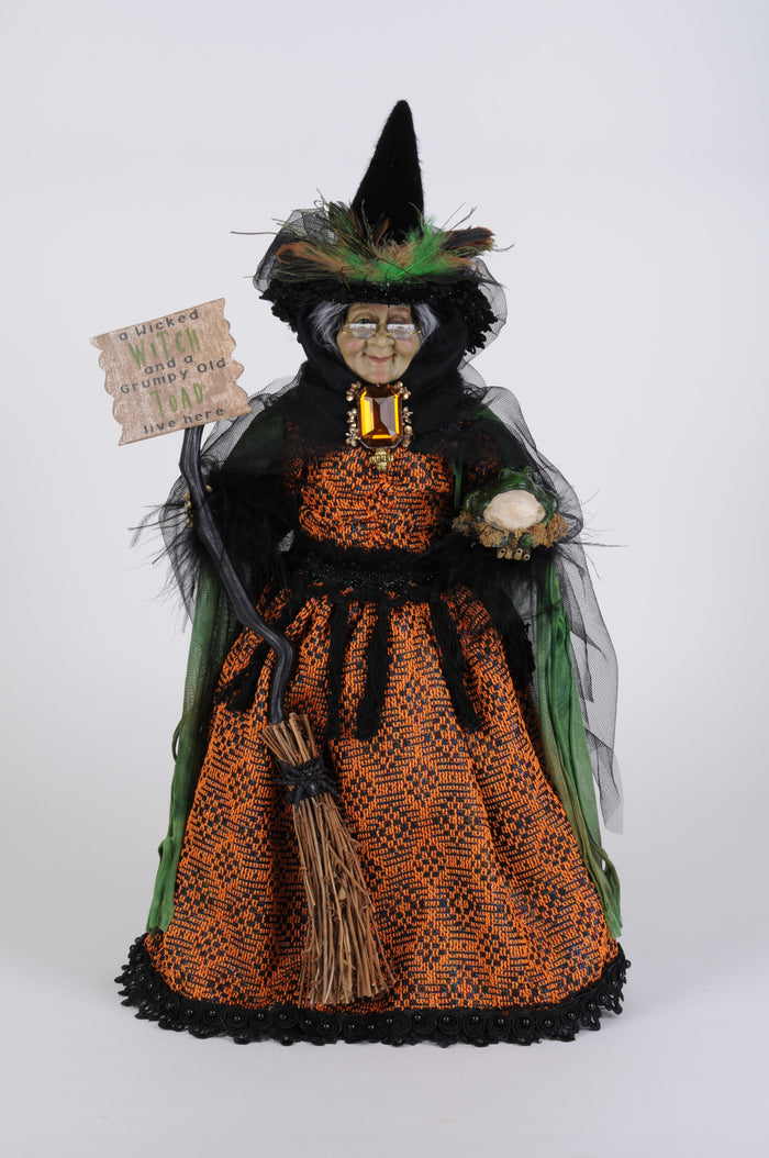 Halloween witch figurine with broom and sign on a white background