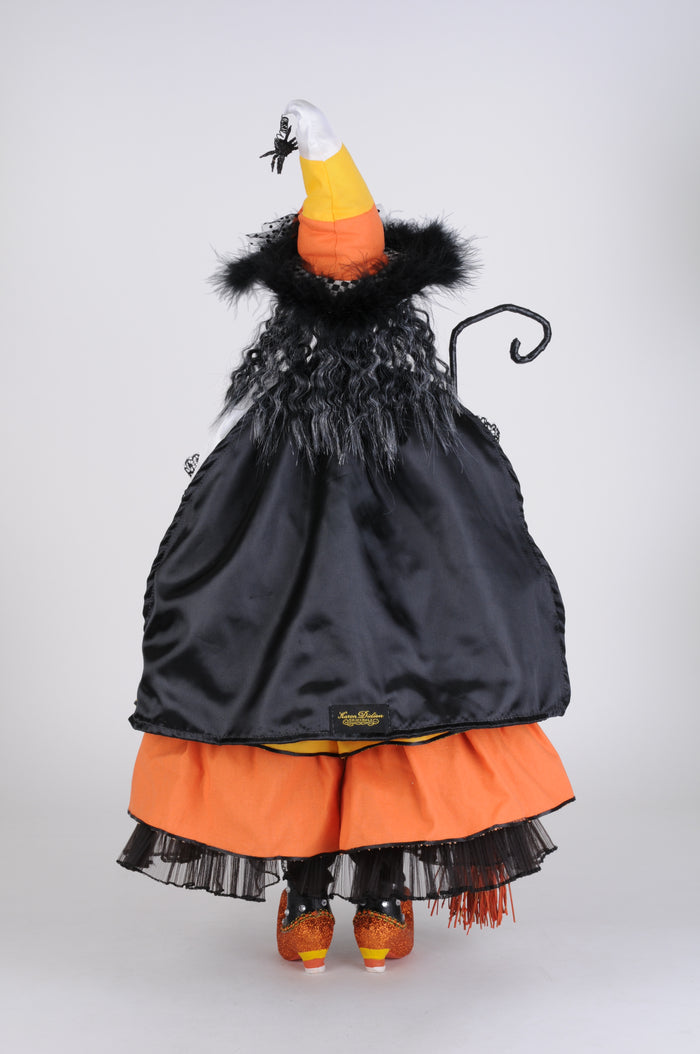 Halloween costume with black cape, orange skirt, and candy corn hat on a white background