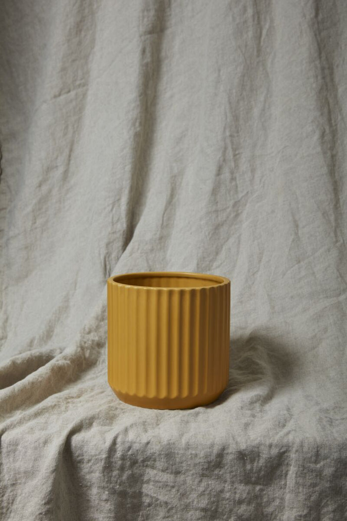 Yellow textured vase on a textured surface