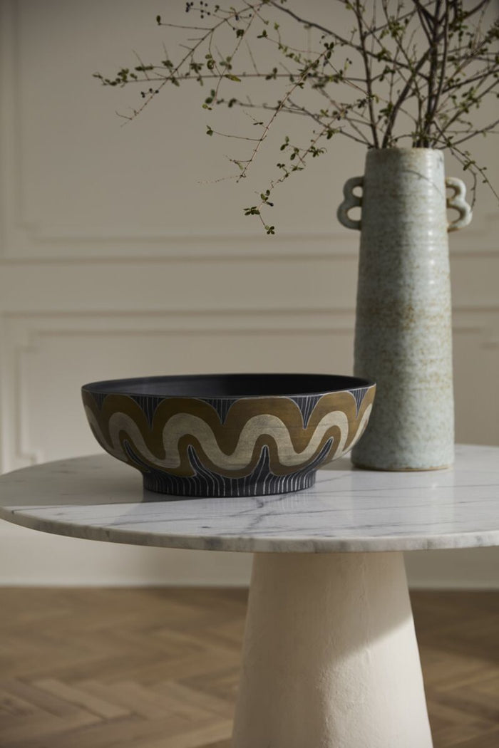Decorative bowl and vase on a marble table with a neutral background