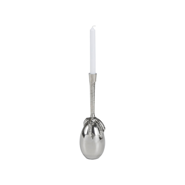Silver spoon-shaped candle holder with a white candle on a white background