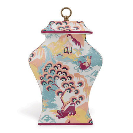 A narrow rectangle porcelain jar with a colorful whimsical pattern featuring dogs, Asian pagodas, ginko trees, and a boat, finished with a solid brass ring on top.