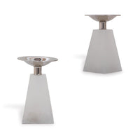Two modern pyramid-shaped white alabaster candleholders with polished nickel metal caps on top, designed to hold candles.
