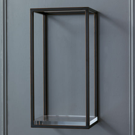 A rectangular bronze metal shelf with a clear acrylic bottom mounted on a wall, against a grey background.