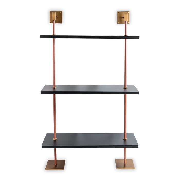 A modern multi-tier shelf unit with black MDF wood shelves, aged brass finished metal poles and faux leather connectors with contrast stitching.