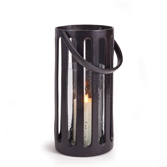 A black cast aluminum hurricane with a seeded glass insert containing a candle, designed for indoor use.