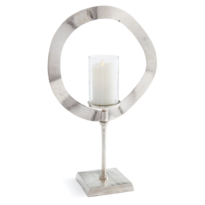 A silver-colored candle stand with a circular frame and a central candle, supported by a cylindrical base.