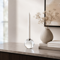 Decorative items including a candle, vase with dried flowers, and books on a surface.