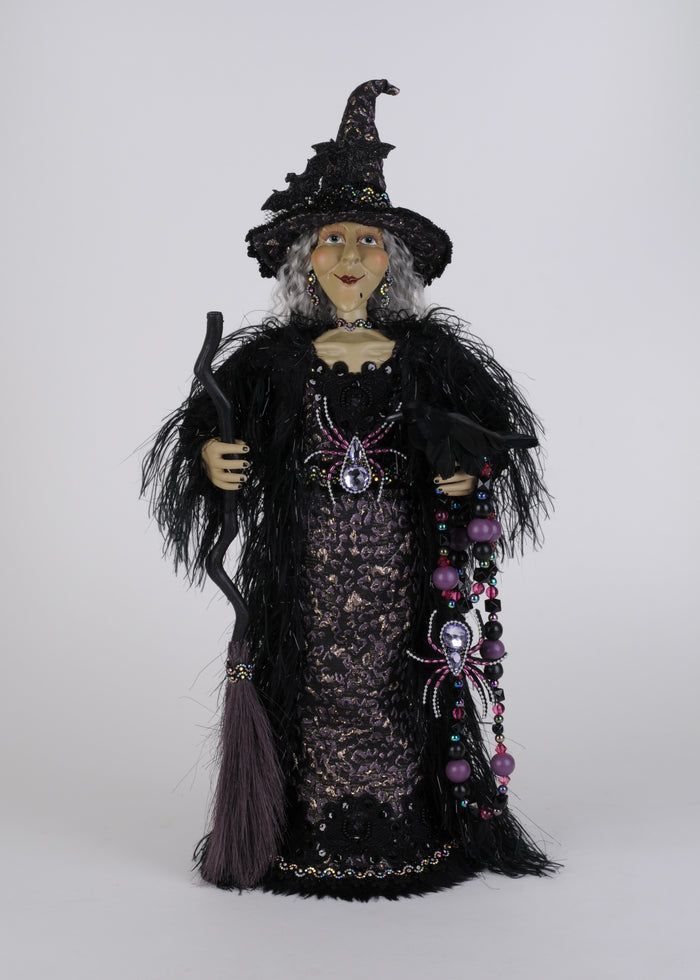 Decorative witch figurine with a broom on a white background