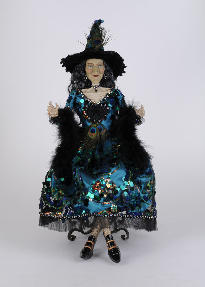 Decorative witch doll in a blue and black outfit with a hat on a white background