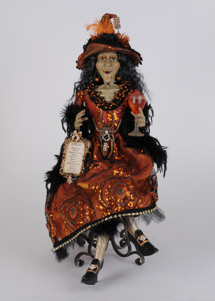 Decorative doll in an ornate costume with a hat and holding a sign on a white background