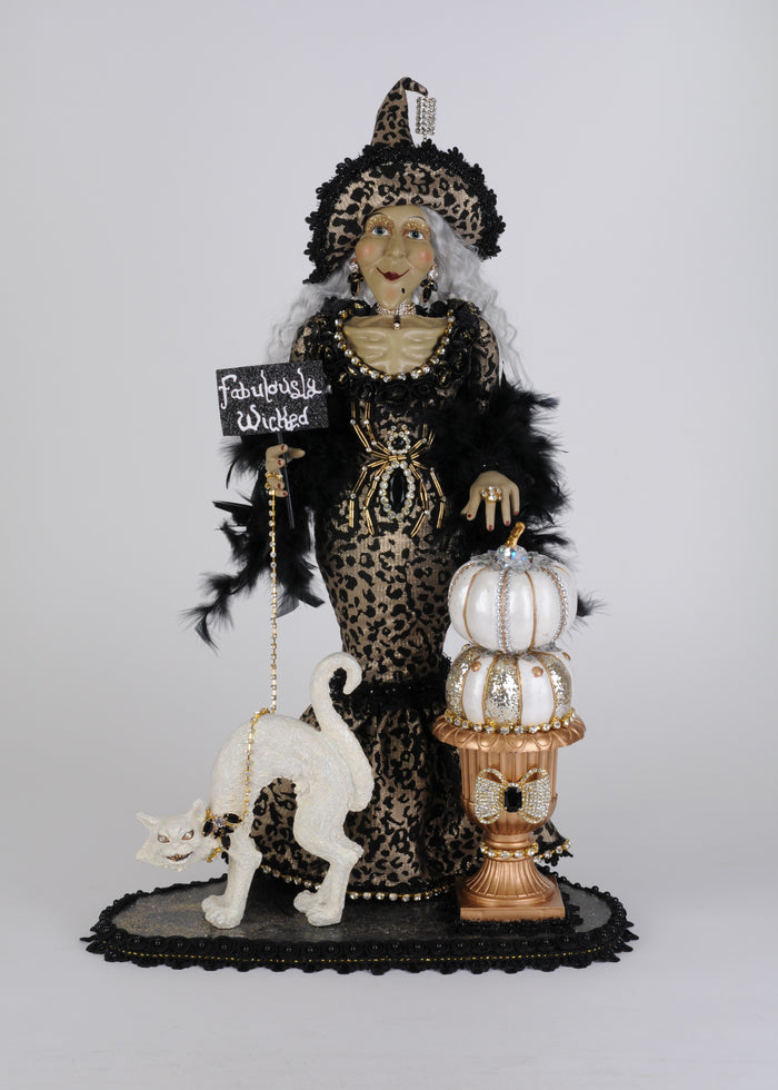 Decorative figure of a witch with a black cat, pumpkin, and lantern on a white background