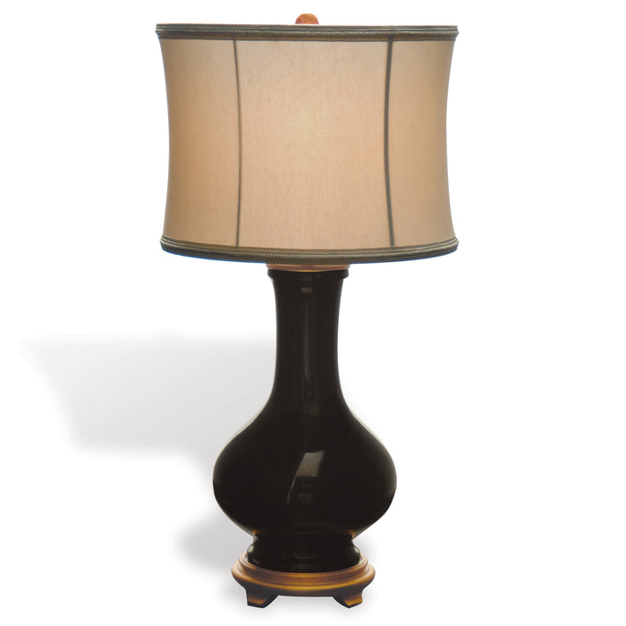 Black table lamp with a beige shade on a white background