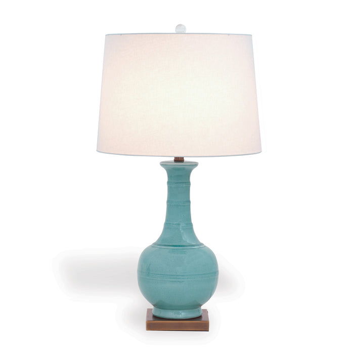 Turquoise table lamp with a white shade on a white background