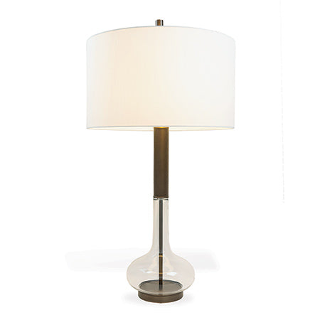 A mid century style lamp with a glass base and bronze finished metal neck and shade.