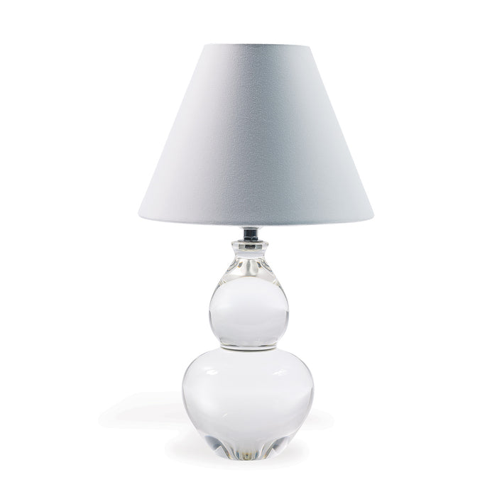 A clear crystal table lamp with a double gourd shape and a tapered white hardback shade.
