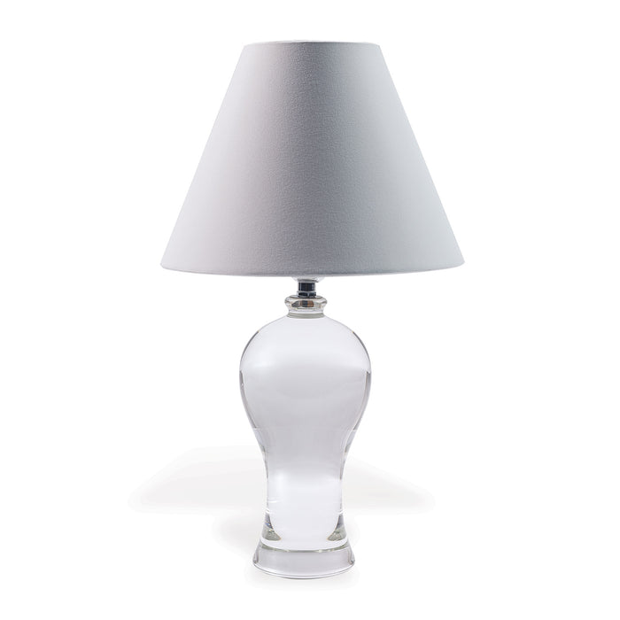 A clear crystal table lamp with a tapered hardback shade, nickel hardware, and a translucent clear on/off line cord.