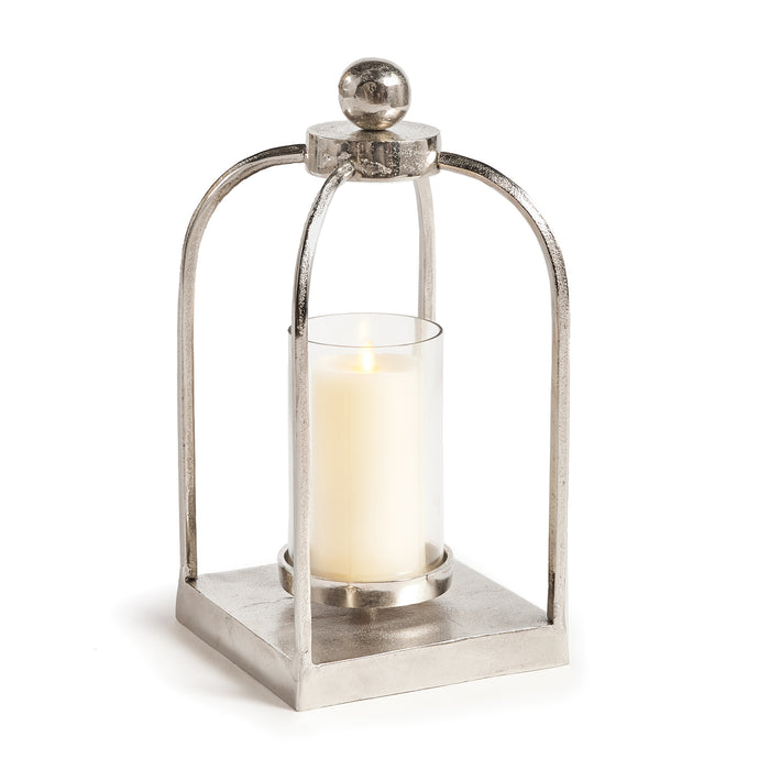 A sleek chrome finish lantern with a rounded finial on top and a lit candle inside, designed for indoor use.