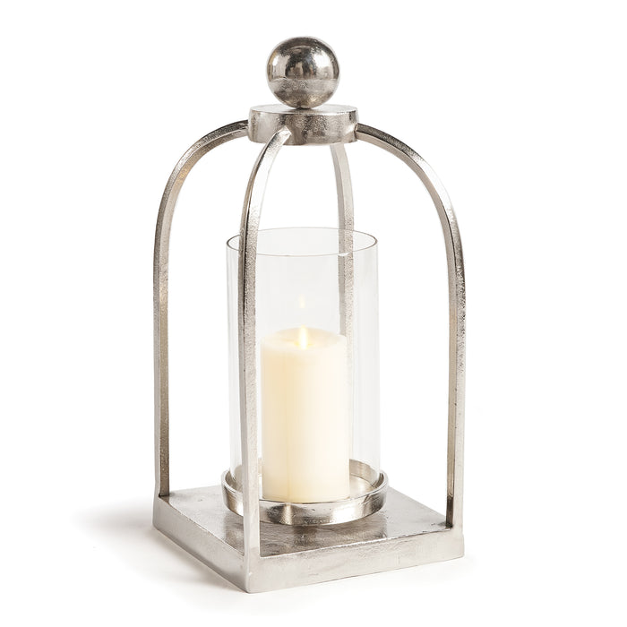 A sleek chrome finish lantern with a rounded finial on top and a clear glass enclosure holding a candle.