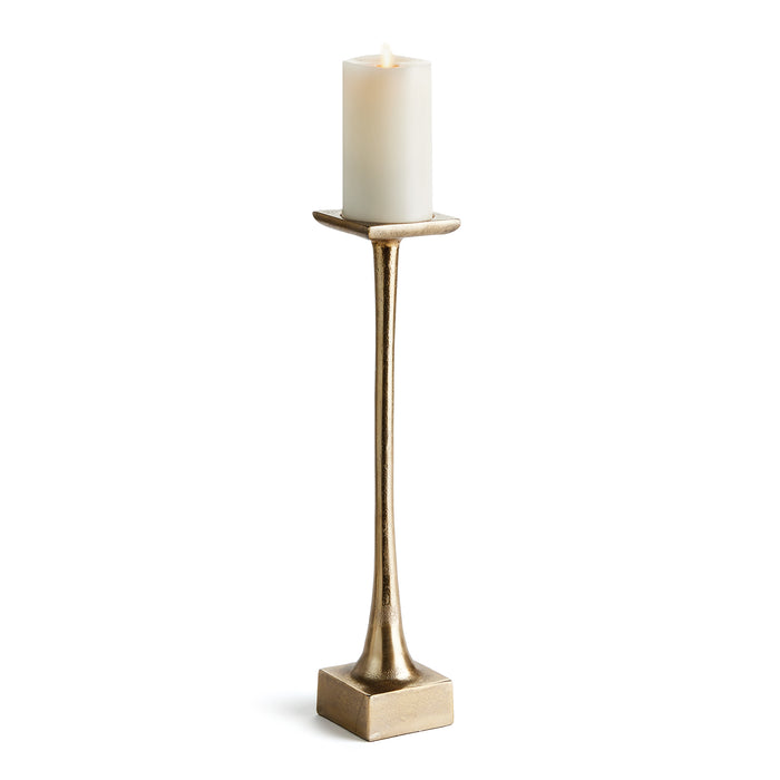 A tall slender gold-colored candle stand with a weighted base, designed for holding a pillar candle.