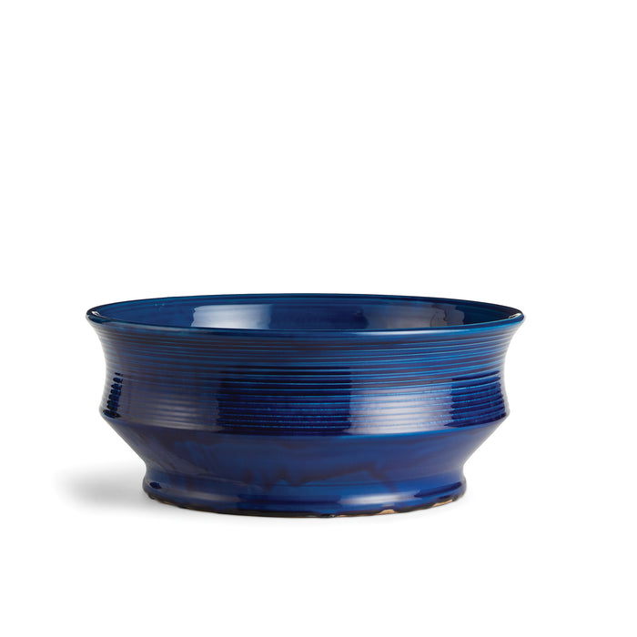 Deep cobalt blue ceramic decorative bowl with horizontal ridges, glossy glaze, on white background.