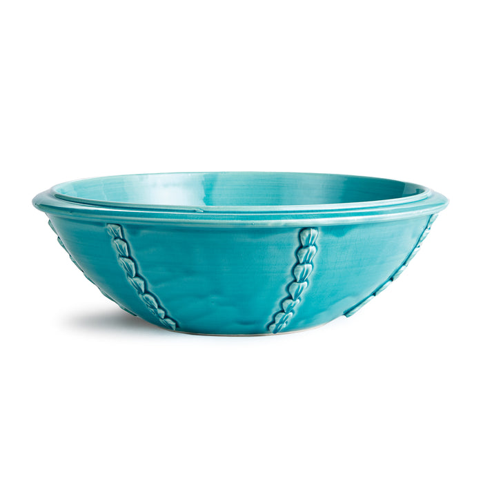 Shallow turquoise ceramic bowl with braided seam accents and glossy glaze on pale interior, isolated on white.