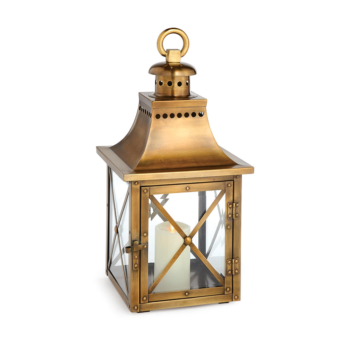 Antique brass lantern with a glass enclosure and a top ring for hanging.