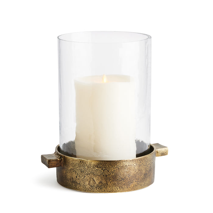 A clear glass hurricane with a hammered glass texture and antique brass finish, featuring a candle inside and simple handles at the top.
