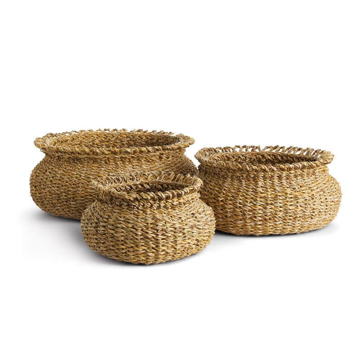 A set of three round seagrass baskets with loop handles on top.
