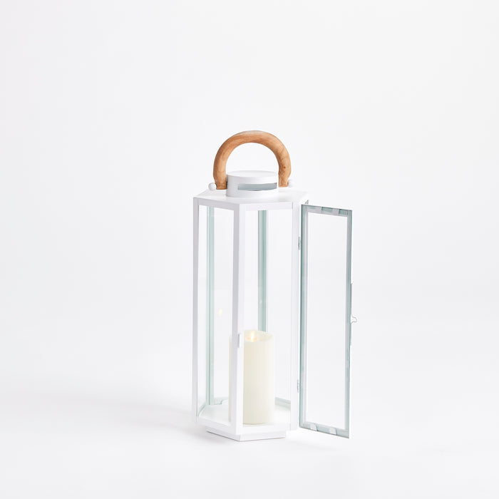 White metal lantern with glass panels, wooden curved handle, hinged door open, yellow candle inside.