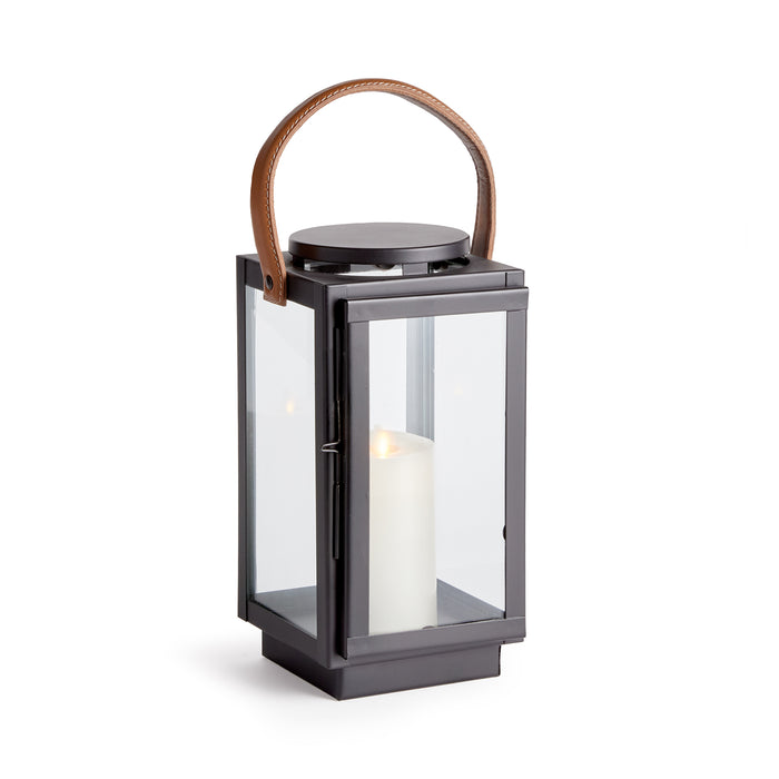 A small lantern with a real leather handle and a glass body, featuring an interior candle holder.
