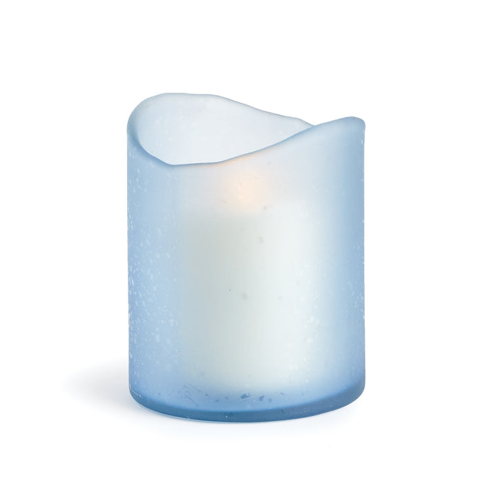 A medium-sized blue glass hurricane candle holder with a melted edge design and a lit candle inside.