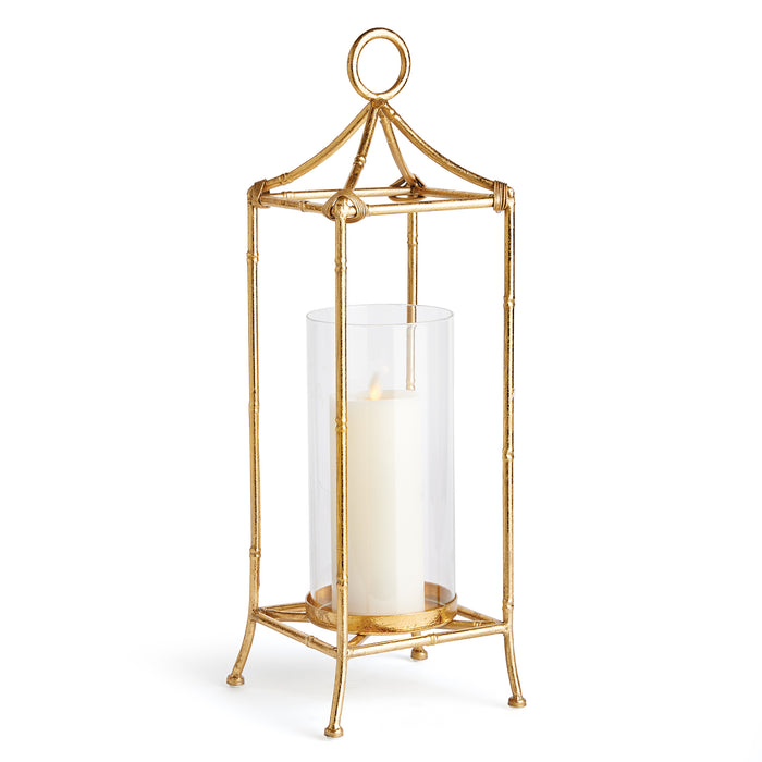 A gold-colored lantern with a glass cylinder and an openwork frame, designed for holding a candle.