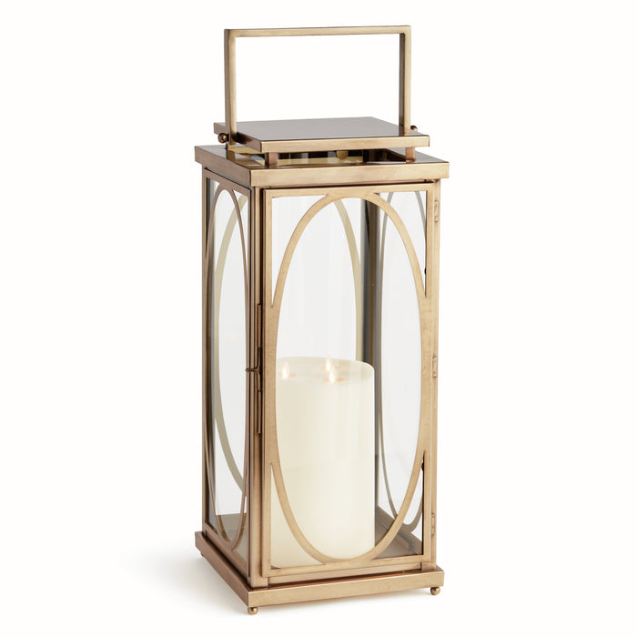 A gold-colored lantern with a geometric oval frame and a lit candle inside, designed for indoor use.