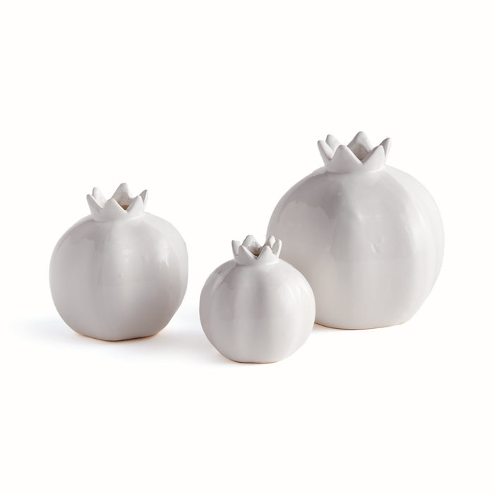 Three white ceramic bud vases in varying sizes with rounded bodies and sculpted crown-like openings, set on a clean white
