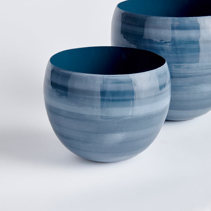 Set of two blue ceramic cachepots with horizontal brushed stripes, dark blue interiors, on white background.
