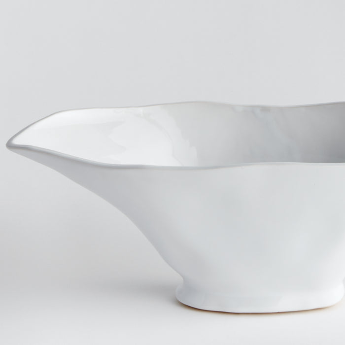 White porcelain oval vase with a curved spout, shallow interior, and rounded base on a light background.