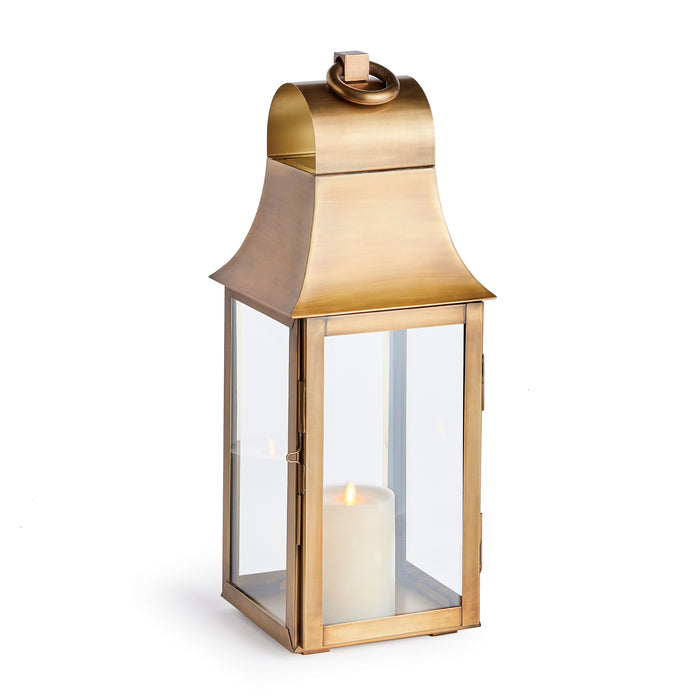 A tall, slender brass lantern with an oversized loop for hanging, featuring a clear glass base and a gold-colored top.