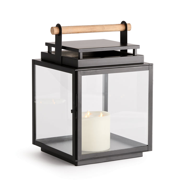 Black metal and glass lantern with a wooden post handle, glass panels, and a candle inside, white background.