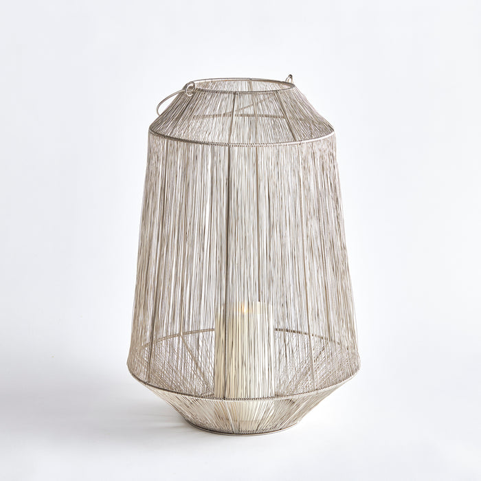Large metal wire lantern with cylindrical tapered mesh, silver finish, open frame, hanging loop, and visible light inside on