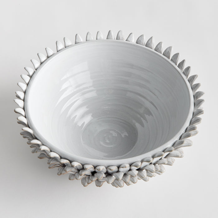 White ceramic bowl with a textured, leaf-like exterior in pale gray; smooth, glossy interior; plain light background.