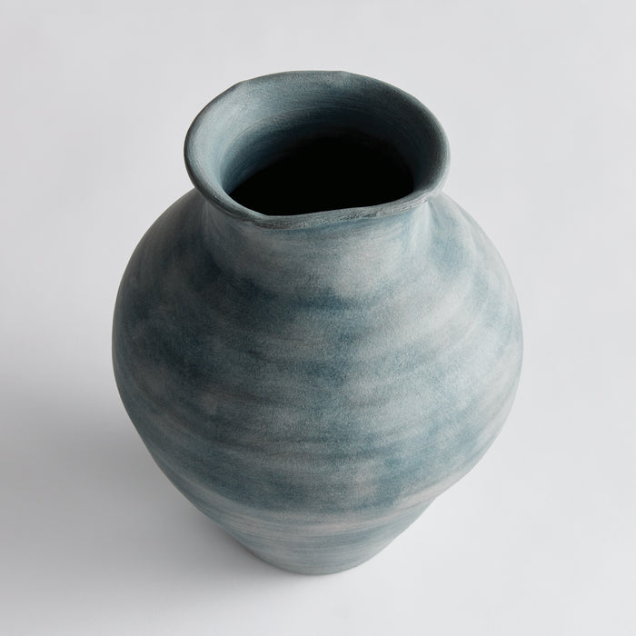 Blue-gray ceramic vase with a rounded body and wide open neck, subtle gradient glaze, plain light background.