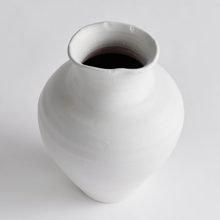 White ceramic vase with a wide rounded body and a slightly irregular, narrow opening; glossy finish, plain background.